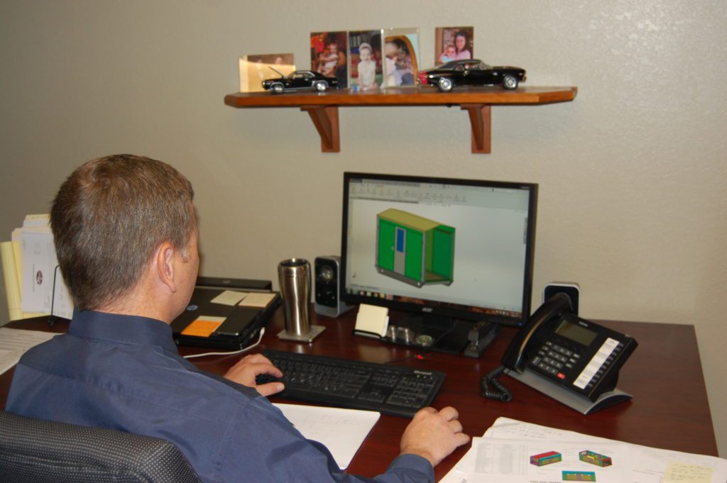 man sitting at desk working on blueprint engineering