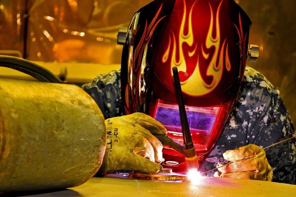 Cross training employees allows this person welding metal to also perform other tasks