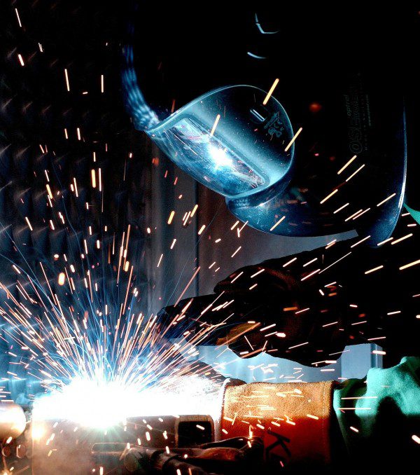 man wearing face shield and welding