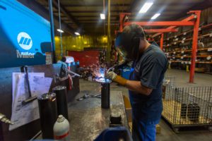 Employee at Metaltech welds on the shop floor.