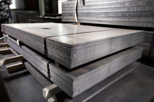 Stainless steel metal sheets deposited in stacks.