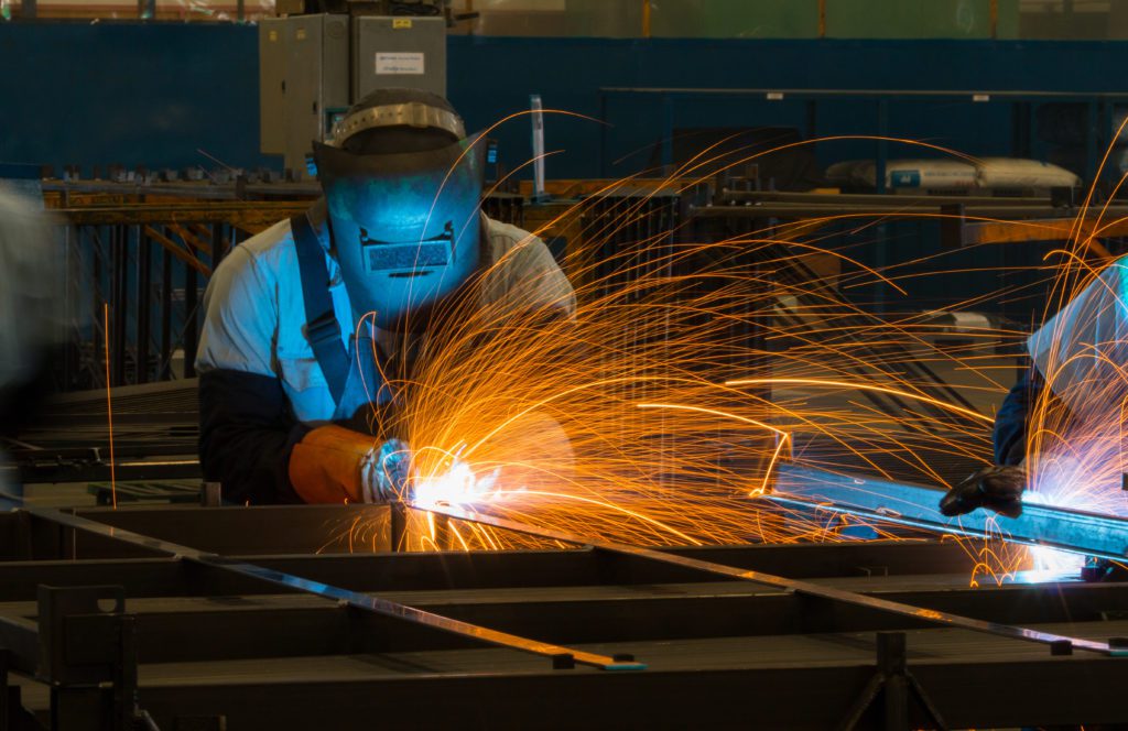 A fabrication welder uses torch to manufacture metal equipment.