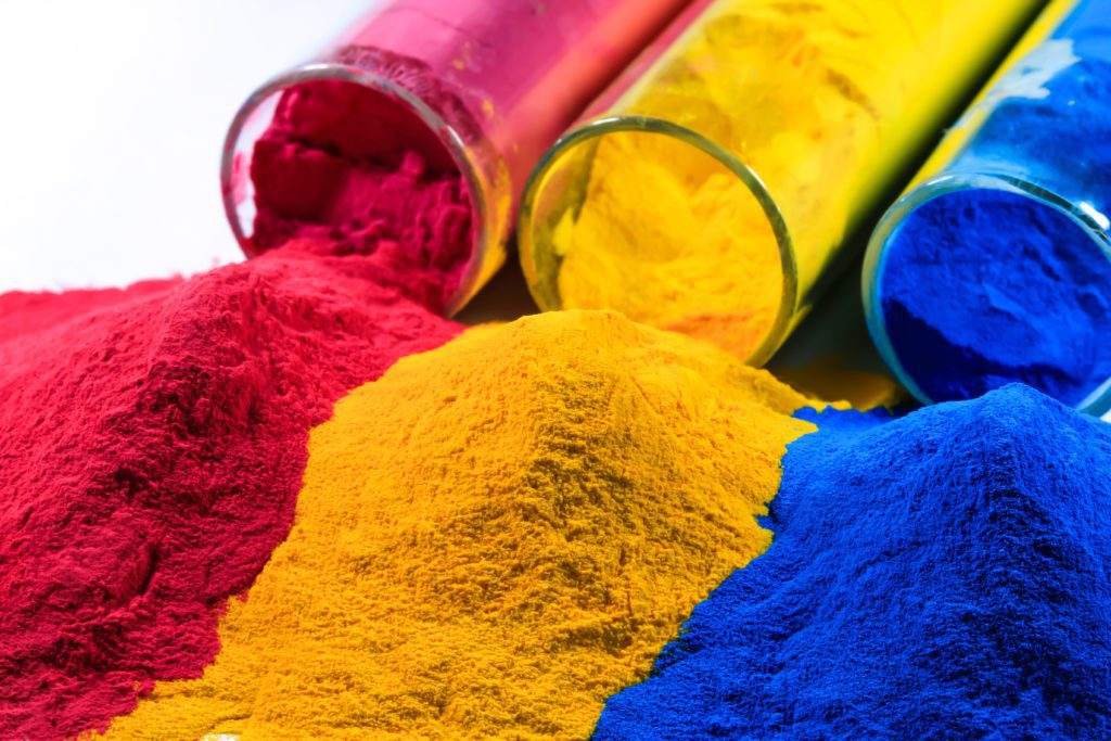 Bright red, yellow and blue powder coating powders in test tubes.