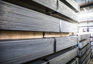 Stainless steel sheets stacked and attached to a shelf for storage.