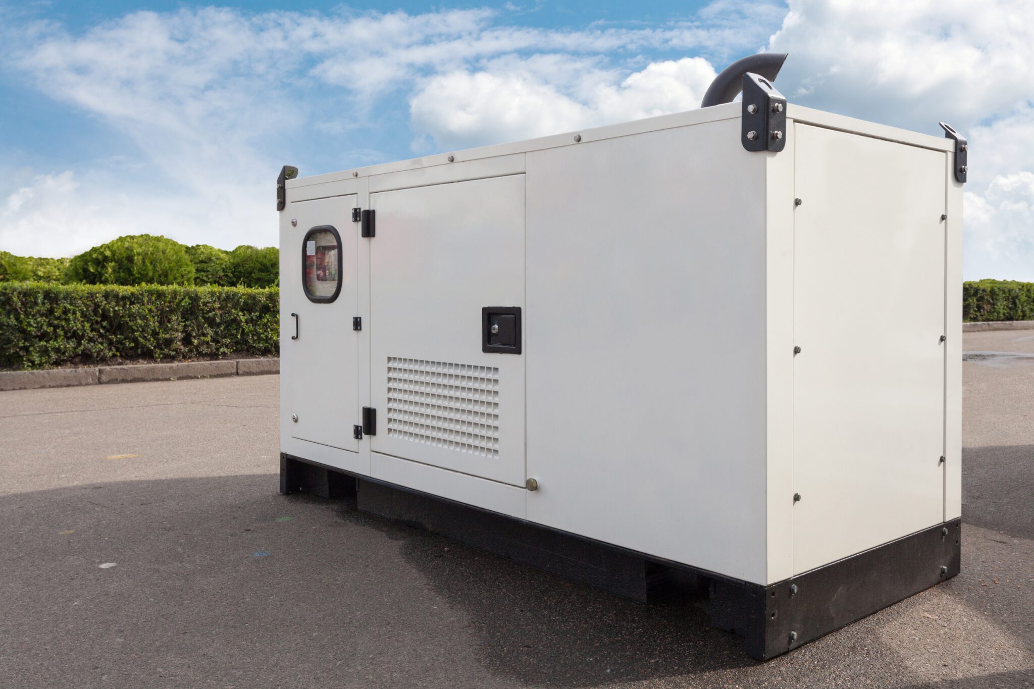A mobile diesel generator with a white enclosure used for emergency electric power.